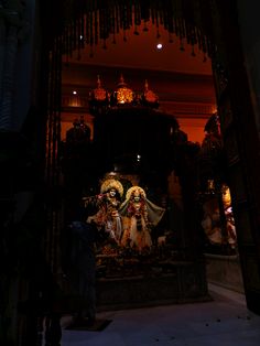 an idol in the middle of a room with lights on and chandeliers hanging from the ceiling