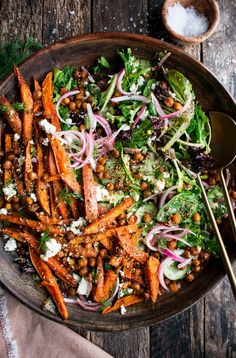 a salad with carrots, lettuce and chickpeas in a bowl