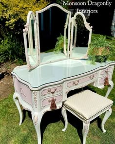 an antique vanity with mirror and stool in the grass