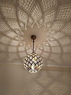 a chandelier hanging from the ceiling in a room with white walls and ceilings