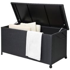 an open wicker storage box with white towels