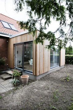 a house that is made out of wood and has sliding glass doors on the outside