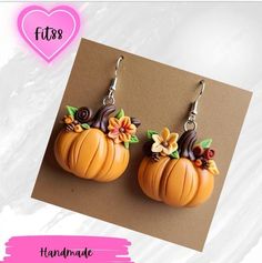 the pumpkin earrings are decorated with flowers and leaves on it's earwires