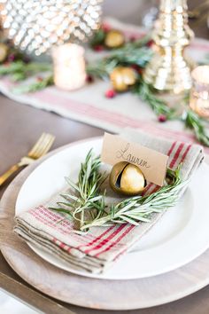 a place setting with pine cones and greenery