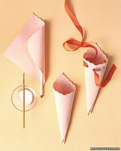 three paper cones with red ribbons on them and one cone has been cut out to look like an ice cream cone