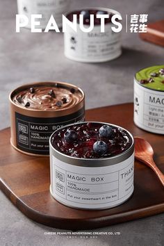 two tins of food sitting on top of a wooden tray next to each other