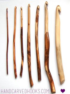 five different types of wooden sticks on a white surface with the words hand carved books written below them