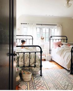 two children are laying in their beds in the room with white walls and wood flooring