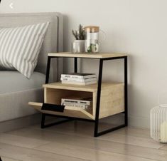 a bed room with a neatly made bed and a night stand on the side table