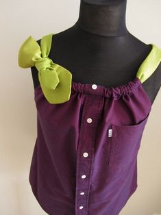 a mannequin wearing a purple shirt with a green bow