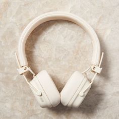 a pair of white headphones sitting on top of a marble counter next to a wall