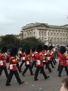 a group of men in red uniforms marching down the street