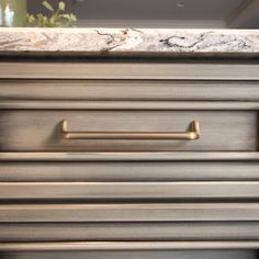 a close up view of the handles on a drawer with marble counter tops and drawers