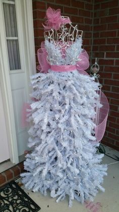 a white christmas tree with pink bows and a tiara on top