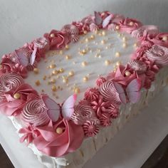 a white cake with pink flowers and butterflies on it