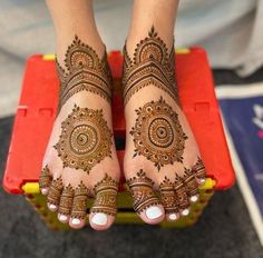 a woman's feet with henna tattoos on them