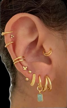 a woman's ear with several different types of piercings