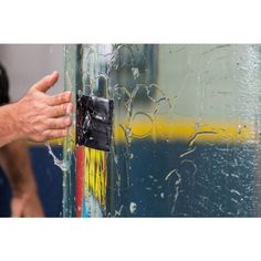 a man is holding his hand on the glass door with water droplets all over it