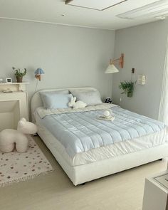 a white bed sitting in a bedroom on top of a hard wood floor next to a window