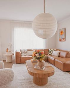 a living room filled with furniture and a large white ball hanging over the top of it