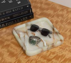 a pair of sunglasses sitting on top of a marble tray next to two bookends