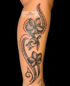 a woman's leg with tattoos on it and flowers in the shape of a heart