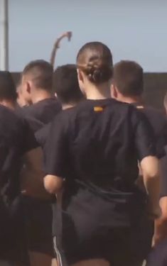 a group of men standing next to each other on top of a soccer field in uniforms