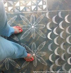 a woman standing on top of a tiled floor next to a flowered design in white and black