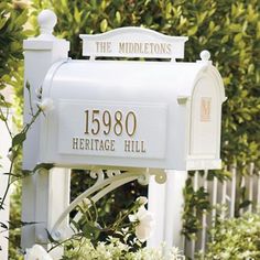 a white mailbox sitting in the middle of some bushes