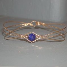 A sweet design of three strands of 14kt gold filled wire featuring a single 6mm genuine lapis bead flanked by two small 14kt gold filled beads. So Metal Wire Bracelet, Elegant Adjustable Wrap Bracelet For Gift, Elegant Adjustable Wrap Bracelet Gift, Adjustable Wrap Bracelet For Friendship, Elegant Adjustable Hand Wrapped Bracelet, Adjustable Stackable Wrap Bracelet Gift, Adjustable Wire Wrapped Wrap Bracelet Bangle, Adjustable Wire Wrapped Wrap Bracelet, Adjustable Hand Wrapped Bracelet