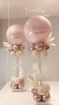 two pink and white balloons on top of each other in front of a mirror with the words, baby shower