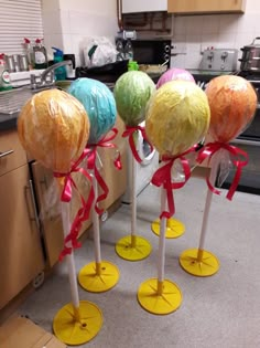 some candy lollipops are sitting on top of poles in the middle of a kitchen