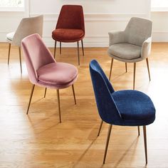 four different colored chairs sitting on top of a hard wood floor