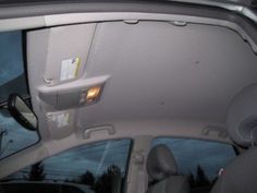 the interior of a car with its sunroof and passenger side view mirror visible