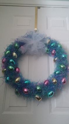 a wreath with ornaments hanging on the front door