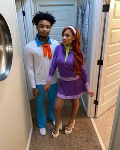 a man and woman dressed up in costume standing next to each other on the hallway