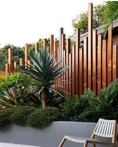 an outdoor garden with wooden slats and plants on the sides, along with a lawn chair