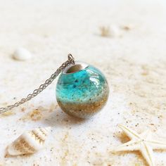 I have the pleasure of presenting you this ocean necklace, a beach sand necklace that belongs to my real sand jewelry. A perfect ocean gift for her to always be in connection with the sea. Let this sphere necklace be your perfect complement for this season or the most original ocean gift. You can combine this ocean necklace with your white or black garments for your formal occasions; Or combine my beach sand necklace with pastel colors for those other more casual ones. Anyway, you will look grea Ocean-inspired Pendant Necklace, Handmade Ocean-inspired Blue Necklaces, Handmade Ocean-inspired Ocean Color Necklaces, Ocean-inspired Turquoise Pendant Necklace, Handmade Ocean Color Necklace For Gift, Ocean Color Pendant Necklace As Gift, Handmade Ocean Color Necklaces For Jewelry Making, Ocean-inspired Jewelry As Gift, Ocean-inspired Jewelry As A Gift