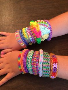 two children's hands with colorful bracelets on them