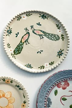 three plates with designs painted on them sitting next to each other