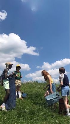 several people standing in the grass with suitcases