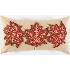 an embroidered pillow with red leaves on it