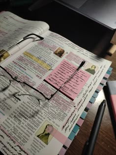 a book with glasses on top of it next to a pen and eyeglasses