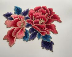 two red and blue flowers on a white surface