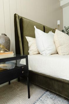 a bed sitting next to a night stand on top of a table