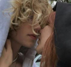 two young women with blonde hair are kissing each other