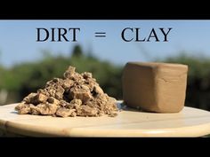 a pile of dirt sitting on top of a wooden table next to a clay block