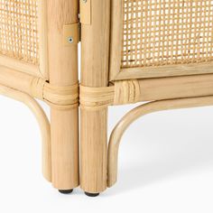 the back end of a wicker chair with two legs and an armrests