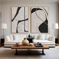 a living room with two paintings on the wall and a coffee table in front of it