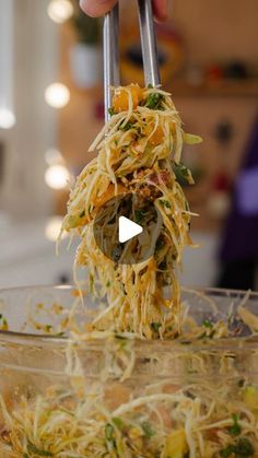 someone is lifting food out of a glass bowl